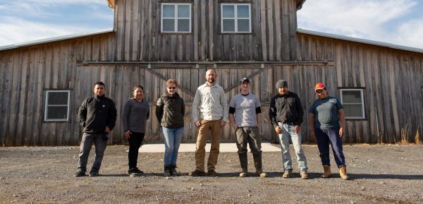 Group of farm employees in front of the barn